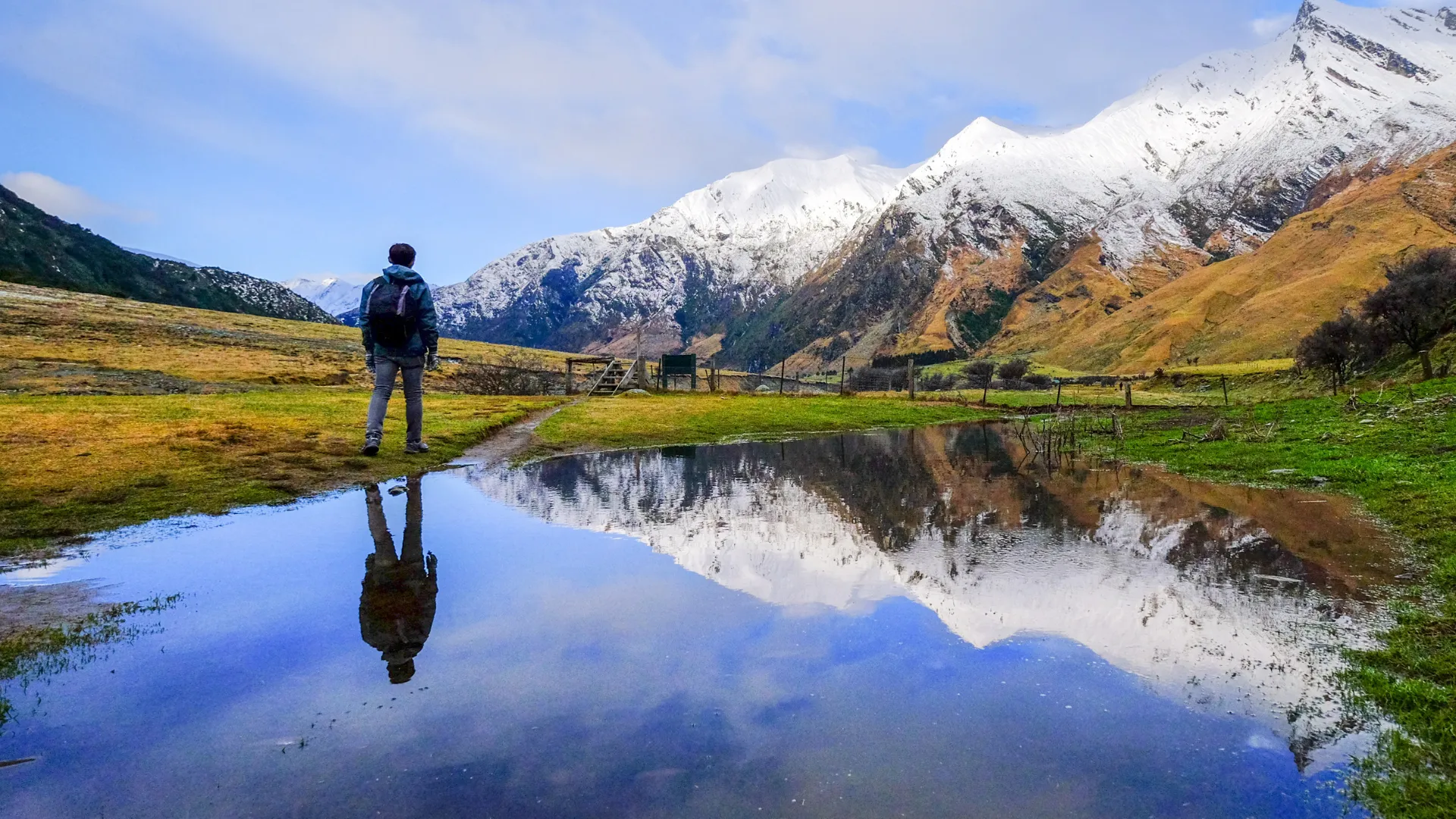 A hiker overlooking a turquoise alpine lake in the Cascade Mountains